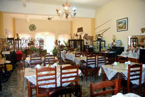 a dining room with tables and chairs and a chandelier at Pousada Oca Porã in Conservatória
