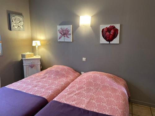 sypialnia z 2 łóżkami i obrazami na ścianie w obiekcie Jardin Secret au Cœur de la Dourd’halie w mieście Saint-Avold