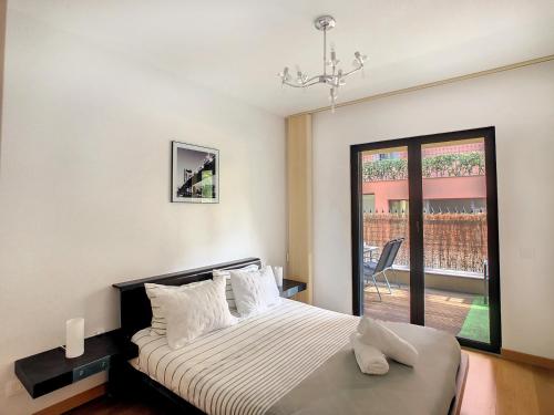 a bedroom with a bed and a large window at Samya Apartment by LovelyStay in Funchal