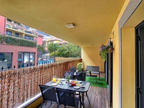 a table and chairs on the balcony of a house at Samya Apartment by LovelyStay in Funchal