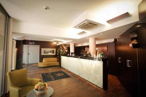 フランクフルト・アム・マインにあるThe Atrium Hotelのホテルのロビーにはバーと椅子があります。