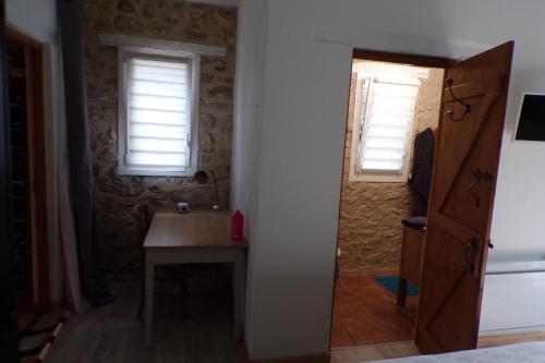 Cette petite chambre dispose d'une table et de deux fenêtres. dans l'établissement chambres d'hotes Chez Maggie, à Saint-Martin-de-Gurçon