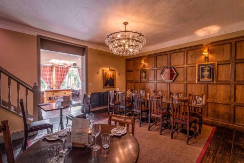 a dining room with tables and chairs and a chandelier at Crown & Punchbowl in Cambridge