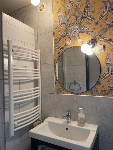 W łazience znajduje się umywalka i lustro. w obiekcie Jardin Secret au Cœur de la Dourd’halie w mieście Saint-Avold