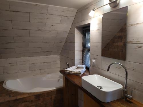 a bathroom with a white tub and a sink at Forest Romantic Apartment Brdy in Věšín