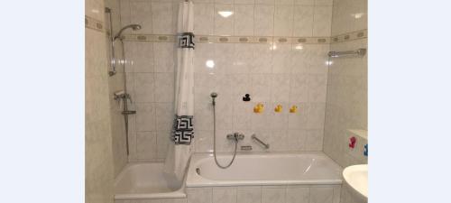 a bathroom with a bath tub and a sink at Ferienwohnung-Rottachseeblick in Sulzberg