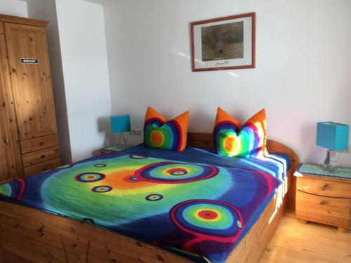 a bedroom with a colorful bed with colorful pillows at Ferienwohnung-Rottachseeblick in Sulzberg