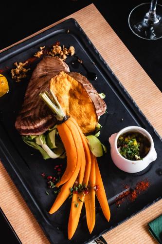 a plate of food with meat and carrots on a table at ibis Styles Castelnaudary in Castelnaudary