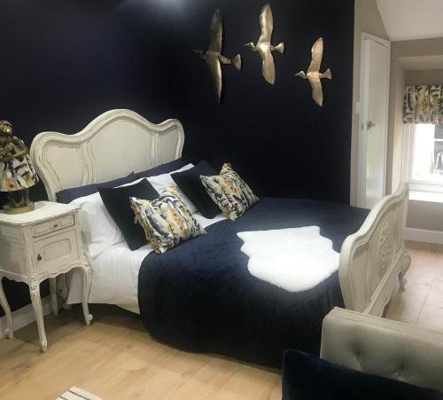 a bedroom with a bed with birds on the wall at 1-Bed luxury studio Apartment Cockermouth in Cockermouth