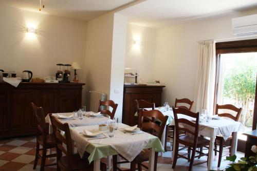 a dining room with tables and chairs and a window at L'Alloggio-Not just rooms in Olbia