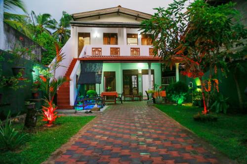 a house with a brick path in front of it at Sanda Hiru Guest in Mirissa