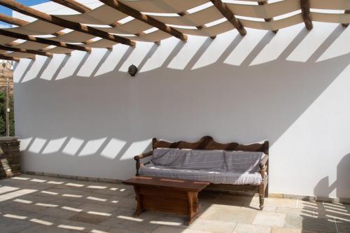 a bench in a white wall with a wooden ceiling at Apollon-Artemis Apartments in Apollonia