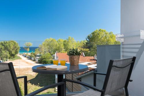a table on a balcony with a view of the water at Princess Golden Beach Hotel in Chrysi Ammoudia