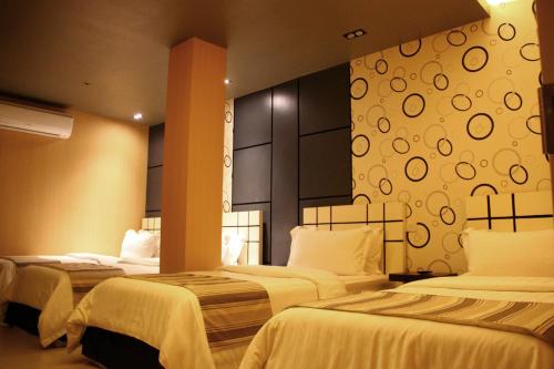 a hotel room with two beds with white sheets at Eloisa Royal Suites in Mactan