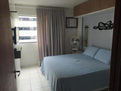 a bedroom with a bed and a window at Apartamento na orla de Maceió in Maceió