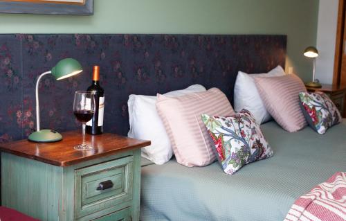 a bedroom with a bed with a bottle of wine and a lamp at Las Bayas Home Suites in Esquel