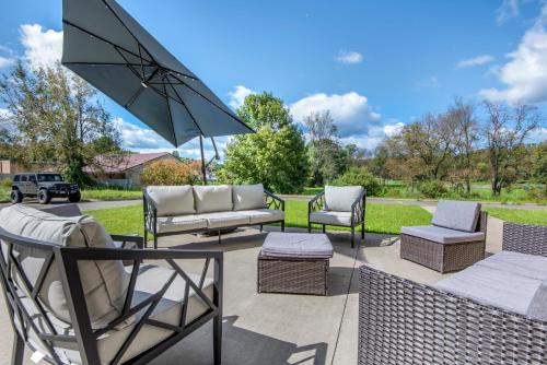 a patio with several chairs and an umbrella at Comfort Inn Apalachin - Binghamton W Route 17 in Apalachin