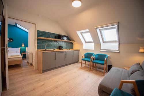 a kitchen with a sink and two chairs in a room at Katarina Birtok in Nemesnádudvar