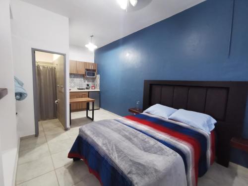 a bedroom with a large bed with a blue wall at Loft Urbano A Pasos d Chapultepec en la Americana in Guadalajara