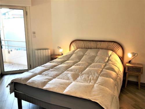 un grand lit dans une chambre avec une fenêtre dans l'établissement LOUISIANE T2 moderne proche plage parking wifi, à Arcachon