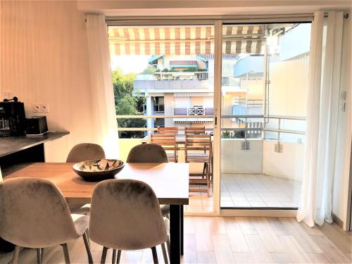 une salle à manger avec une table et des chaises et un balcon dans l'établissement LOUISIANE T2 moderne proche plage parking wifi, à Arcachon