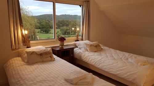 - 2 lits dans une chambre avec une grande fenêtre dans l'établissement Bienvenue pour vous détendre, à Parbayse