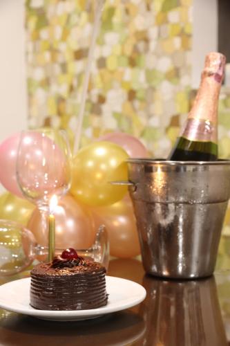 a chocolate cake with a candle on a table with a bottle of champagne at Hotel Vilar América in Bogotá