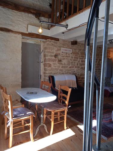 une table et des chaises dans une chambre avec un lit dans l'établissement Maisonnette de Mamie, à Pouilly-en-Auxois