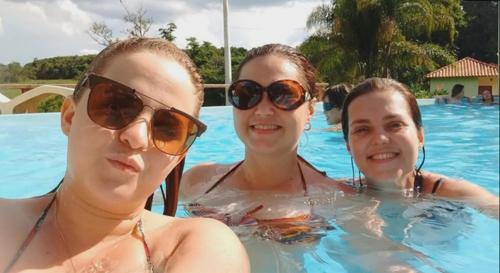 drei Frauen im Schwimmbad mit Sonnenbrille in der Unterkunft BANGALÕ DO LAGO in Caconde