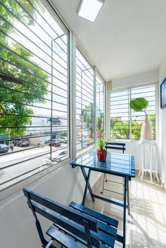 a room with a table and two chairs and windows at Bamboo Hoouse in Santo Domingo