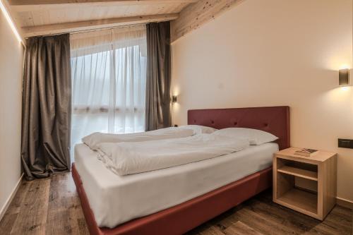 a bedroom with a large bed and a window at Chalet Alpenrose in Misurina