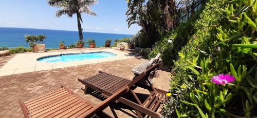 a couple of chairs sitting next to a swimming pool at Seaview Cottage in Ballito