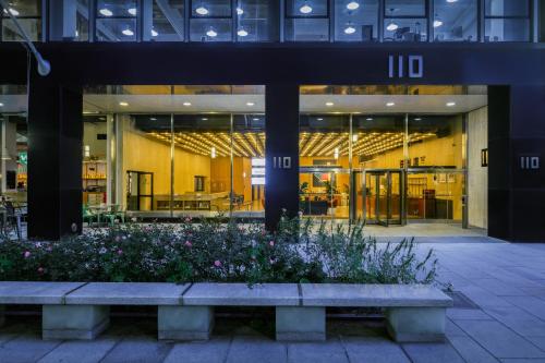 a large building with a bench in front of it at Placemakr Wall Street in New York