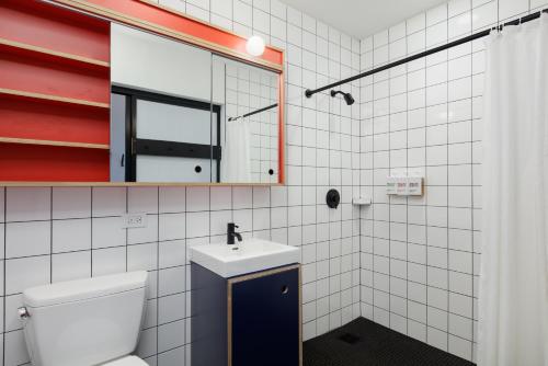 a bathroom with a toilet and a sink and a mirror at Placemakr Wall Street in New York