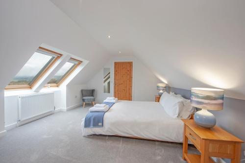 a bedroom with a bed and two windows at Seabank Lodge in Oban