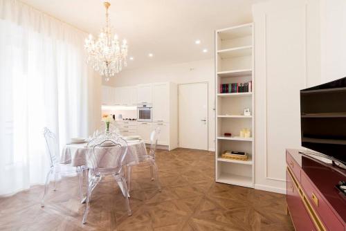 una sala da pranzo con tavolo e lampadario pendente di Madonna Montecchi Luxury Suite in Verona a Verona
