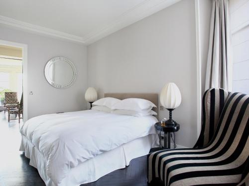 une chambre blanche avec un lit et une chaise dans l'établissement Outstanding 2 bedrooms with a terrific Eiffel Tower view, à Paris