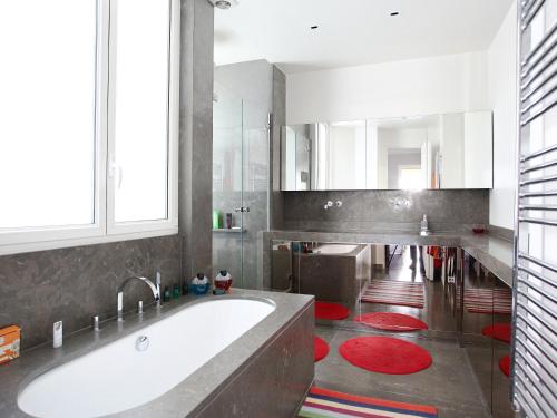une grande salle de bain avec une baignoire et un grand miroir dans l'établissement Outstanding 2 bedrooms with a terrific Eiffel Tower view, à Paris