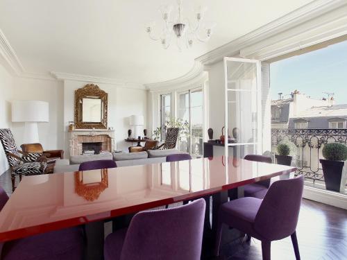 une salle à manger avec une grande table et des chaises violettes dans l'établissement Outstanding 2 bedrooms with a terrific Eiffel Tower view, à Paris