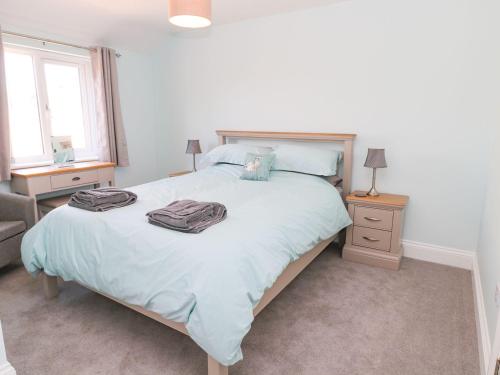 a bedroom with a bed with two towels on it at 3 The Paddock in Chathill