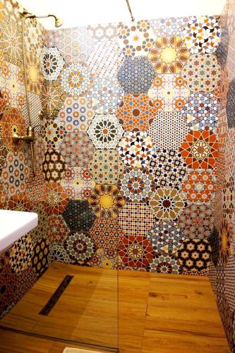 a bathroom with a wall covered in colorful tiles at Filip Apartment Oradea in Oradea