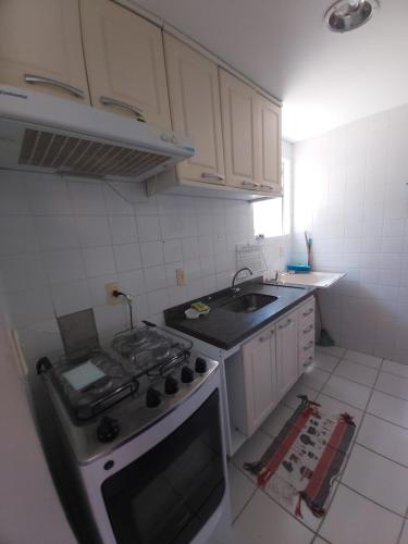 a kitchen with a stove and a sink at Village Hospedagens in Natal
