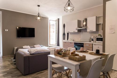 una cucina e un soggiorno con letto e tavolo di Via Mazzini B & B (MXP) a Vizzola Ticino