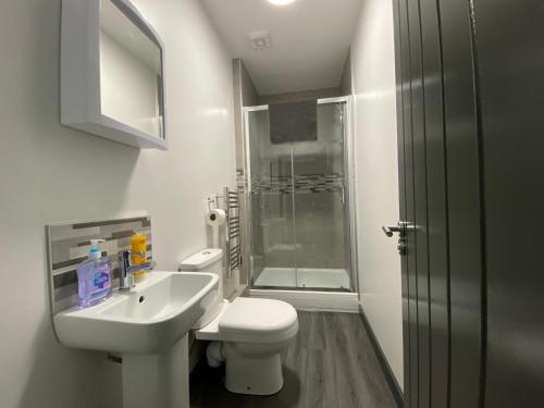 a bathroom with a toilet and a sink and a shower at StayCrewe Apartments in Crewe