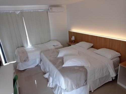 ein Hotelzimmer mit 2 Betten und einem Fenster in der Unterkunft PLC Hotel Centenario in Paso de los Toros