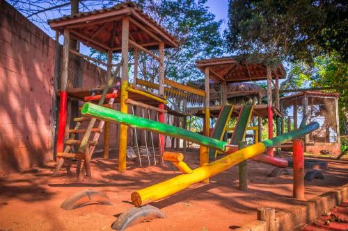 une aire de jeux avec des équipements de jeux colorés dans la terre dans l'établissement Pousada Café da Roça, à Campos Gerais