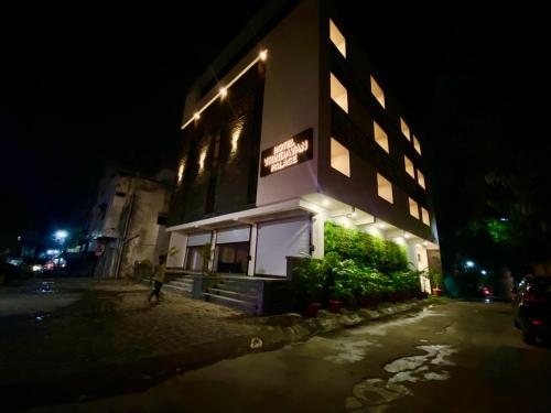 a building with a sign on the side of it at night at Hotel Vrindavan Palace in Indore