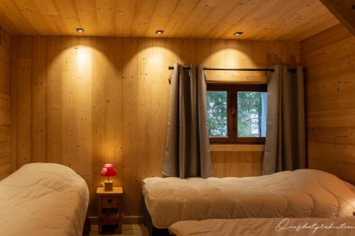 a bedroom with two beds in a log cabin at Boost Your Immo Les Deux Alpes 527 in Les Deux Alpes