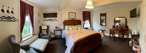 a bedroom with a bed and a chair and windows at Eagle House - award winning luxury B&B and Apartment in Eccleshall