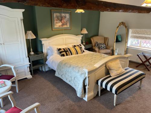 a bedroom with a large bed and a chair at Eagle House - Award Winning B&B and Apartment in Eccleshall